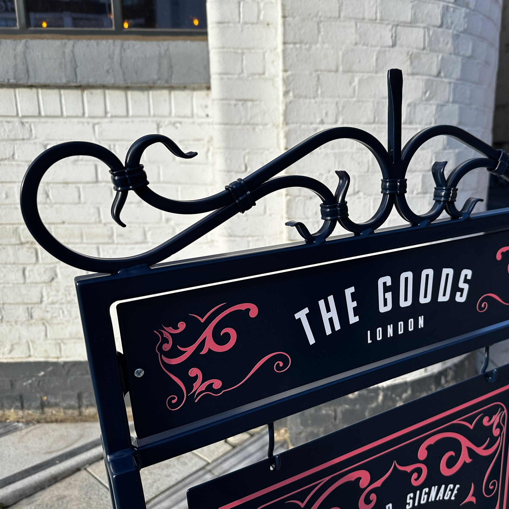 Traditional outdoor metal A board sign with decorative scrollwork.